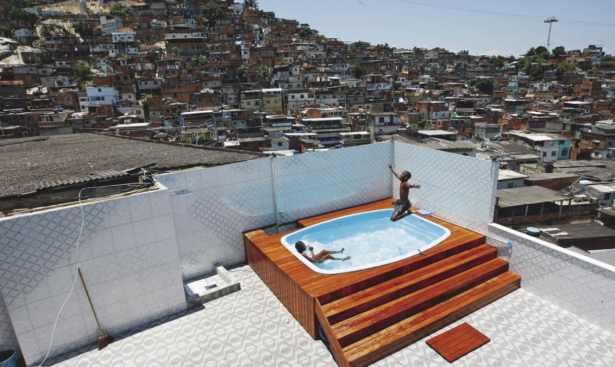 Último piso de uma casa de três pavimentos, que pertencia a um dos chefes do tráfico, onde crianças se divertem na piscina