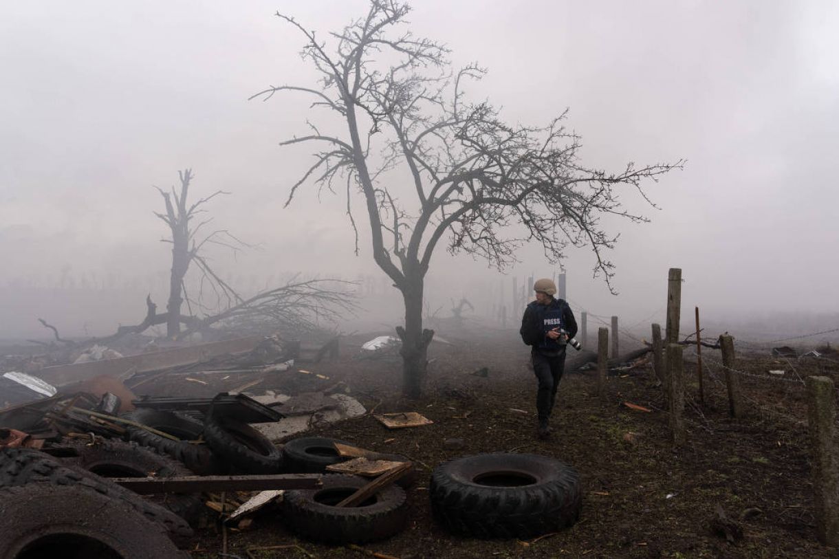 O fotógrafo Evgeniy Maloletka caminha após um ataque russo em Mariupol, em 24 de fevereiro de 2022