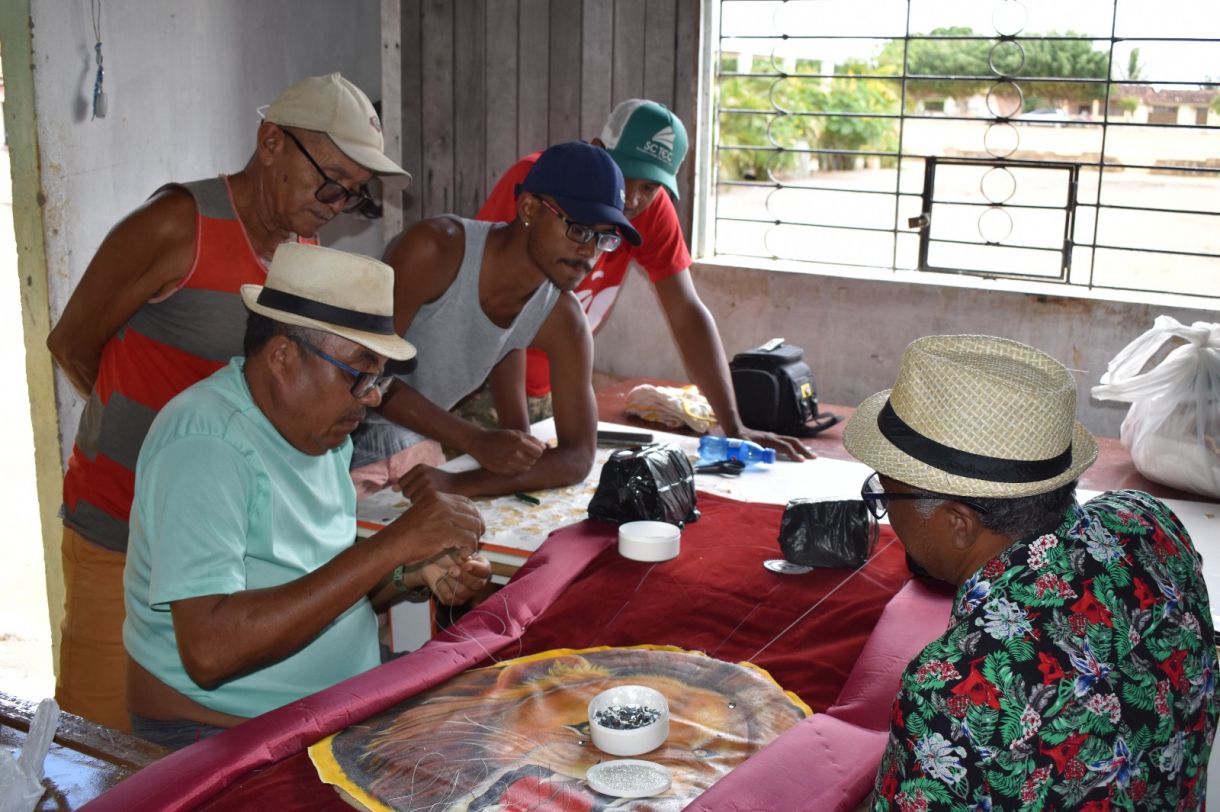 Manoelzinho Salustiano (à esquerda, sentado), mestre artesão, ministrando oficina de bordados